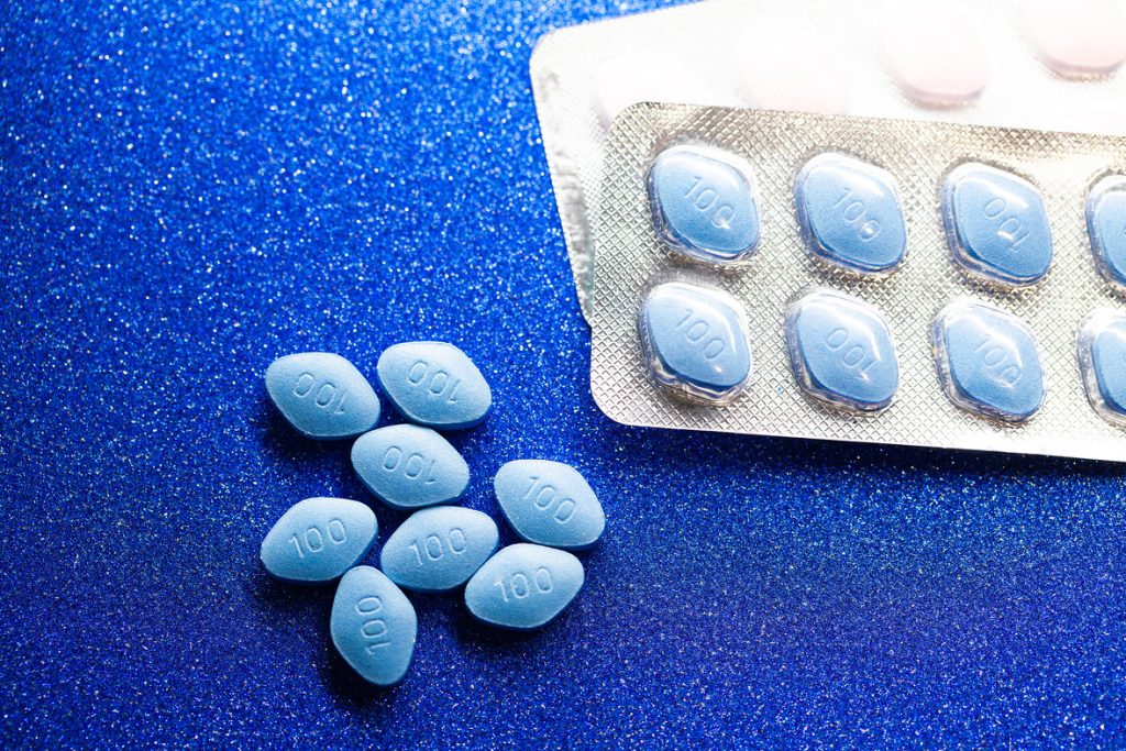 pills of viagra on a blue colored background